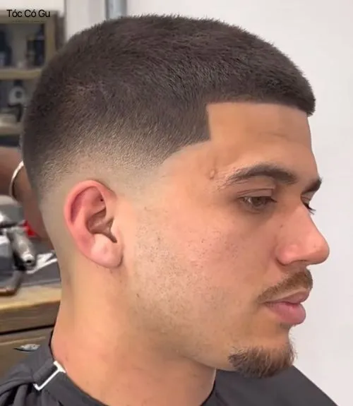Góc nghiêng kiểu tóc buzz cut Low Fade ngắn, gọn gàng với đường viền trán cạo sắc nét và hiệu ứng fade mịn màng ở hai bên