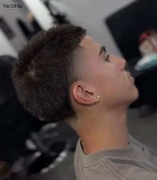 Góc nghiêng của một người nam giới để tóc buzz cut Taper Fade với đường fade mịn màng, sắc nét, tạo vẻ hiện đại