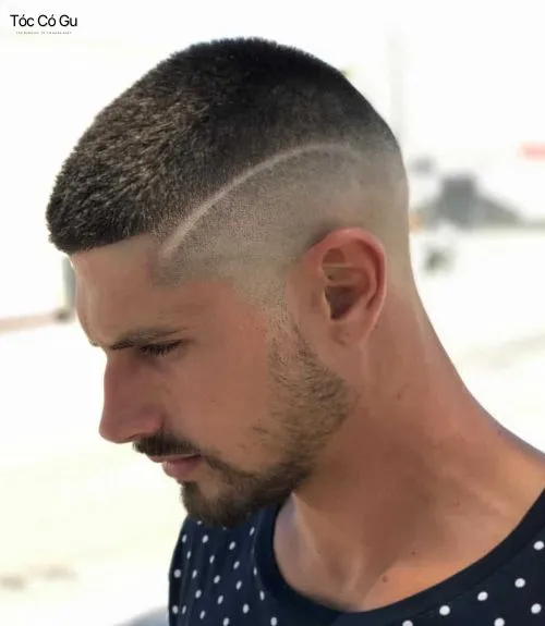 Cận cảnh kiểu tóc buzz cut với rãnh cạo tạo kiểu trên đỉnh đầu, xung quanh được fade rất ngắn