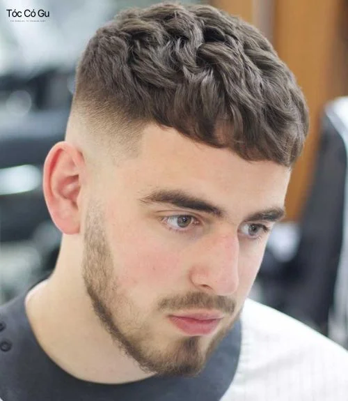 Caesar Cut Fade với phần mái cắt ngang, tóc trên đỉnh tỉa texture và fade cao hai bên tạo hiệu ứng sắc nét.
