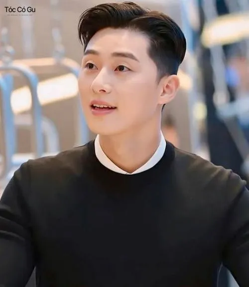 Một người đàn ông trung niên với kiểu tóc crew cut dài gọn gàng và bộ râu quai nón