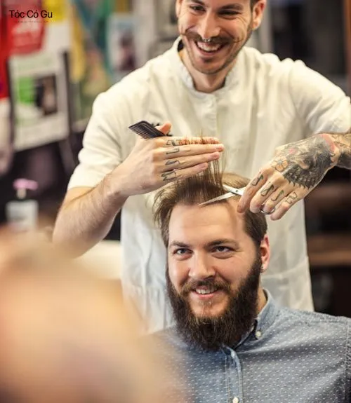 10+ kiểu tóc mái ngố nam đẹp, hot trend giúp trẻ ra vài tuổi Thợ barber đang cắt tỉa tóc nam trong tiệm chuyên nghiệp.