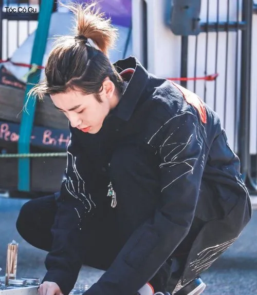 10+ kiểu tóc buộc nam lãng tử, đậm chất nghệ sĩ đầy cuốn hút Chàng trai ngồi trên phố với kiểu tóc buộc nửa đầu thấp nhẹ nhàng, đậm chất lãng tử
