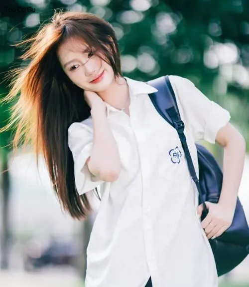 11+ kiểu tóc học sinh nữ cấp 1,2,3 đẹp, xinh xắn và đáng yêu Nữ sinh mặc sơ mi trắng mỉm cười, mái tóc dài tung bay trước gió, gợi ý một kiểu tóc học sinh nữ năng động