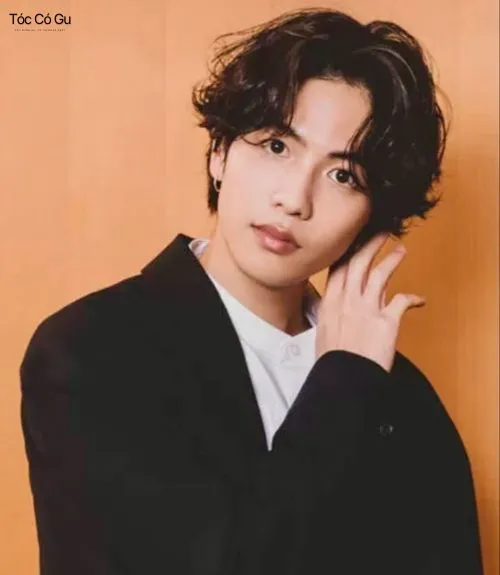 Top 10+ kiểu tóc uốn ruffled cho nam cool ngầu, cực chất Kiểu tóc uốn ruffled Wavy rẽ ngôi sành điệu trên mẫu nam diện áo khoác đen, thể hiện phong cách lịch lãm, hiện đại