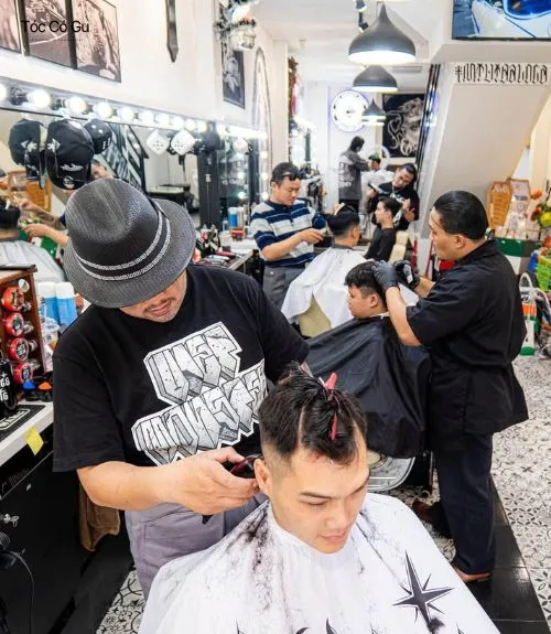 Review Liêm Barber Shop: Giá cả và trải nghiệm thực tế Thợ cắt tóc đang phục vụ khách tại Liêm Barber Shop