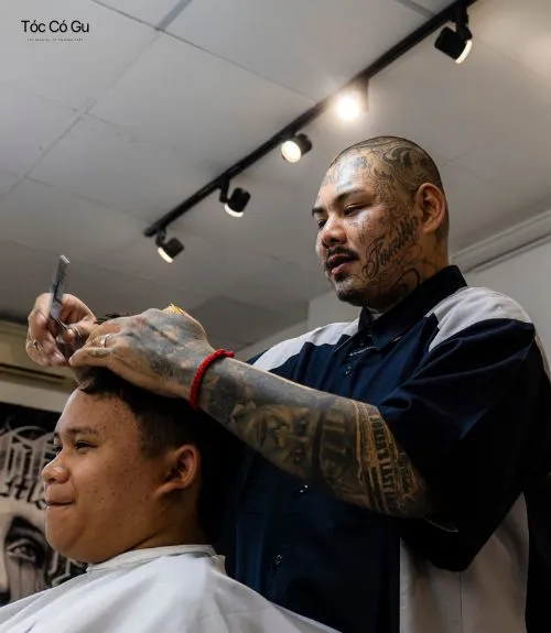 Review Liêm Barber Shop: Giá cả và trải nghiệm thực tế Thợ barber đang dùng kéo cắt tóc cho khách hàng