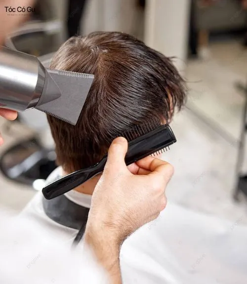Thợ tóc đang sấy và dùng lược tạo kiểu Pre-styling để định hình form tóc ban đầu